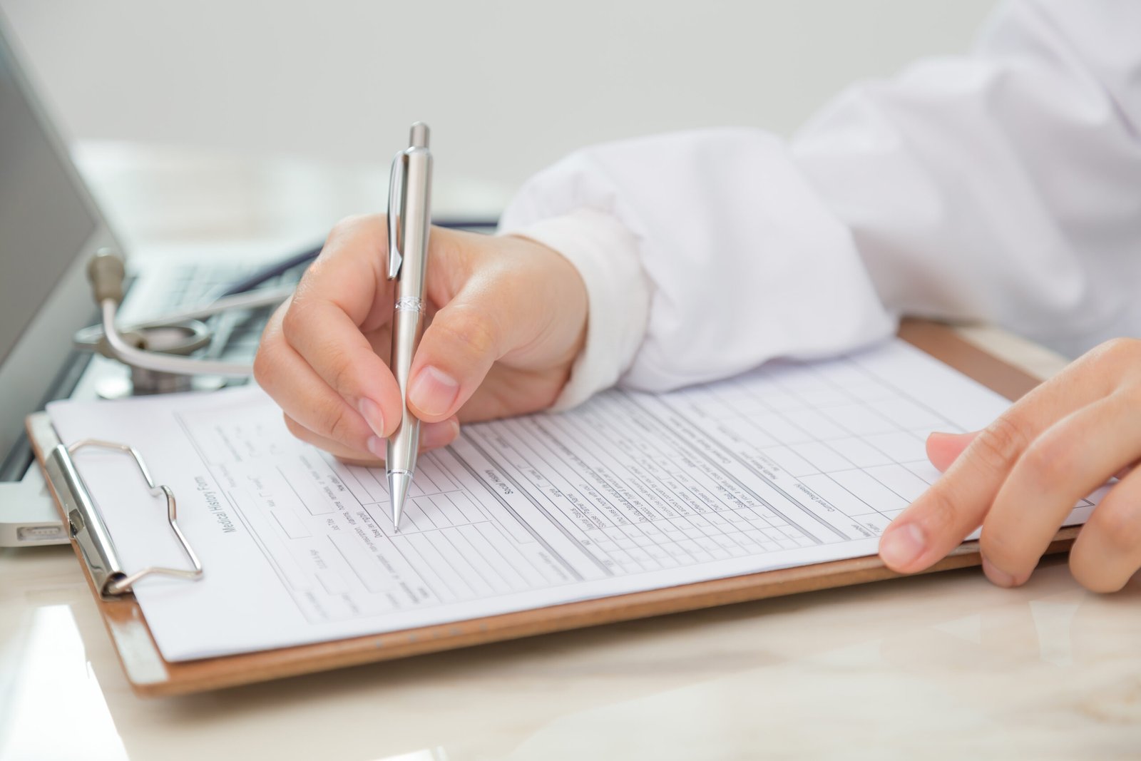 Hand of doctor writing on prescription